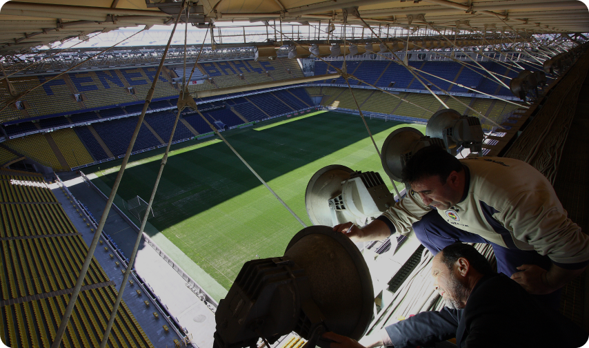 Two people working on stadium lights