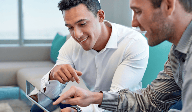 Two men smiling at a tablet