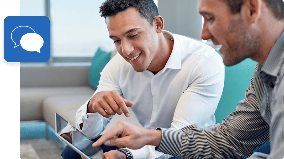 Two guys smiling while using a tablet